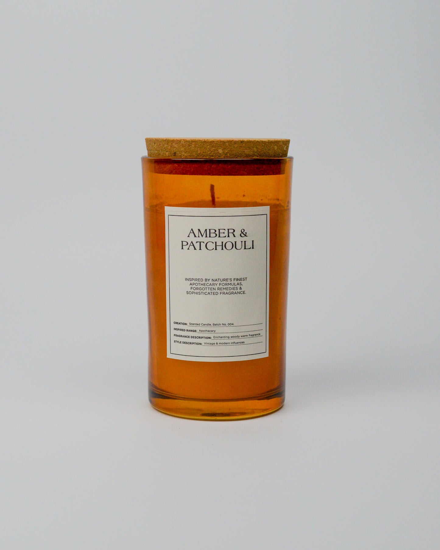 Candle with 'Amber & Patchouli' label on a white background