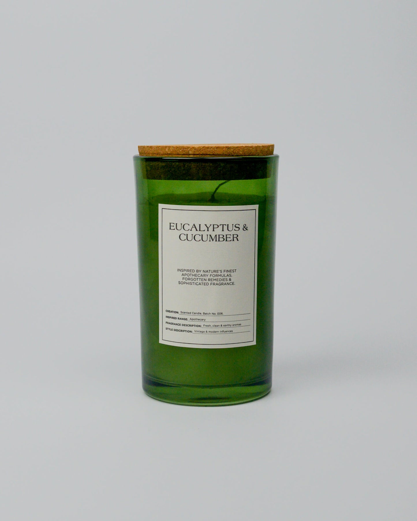 Green eucalyptus and cucumber candle with a cork lid on a white background