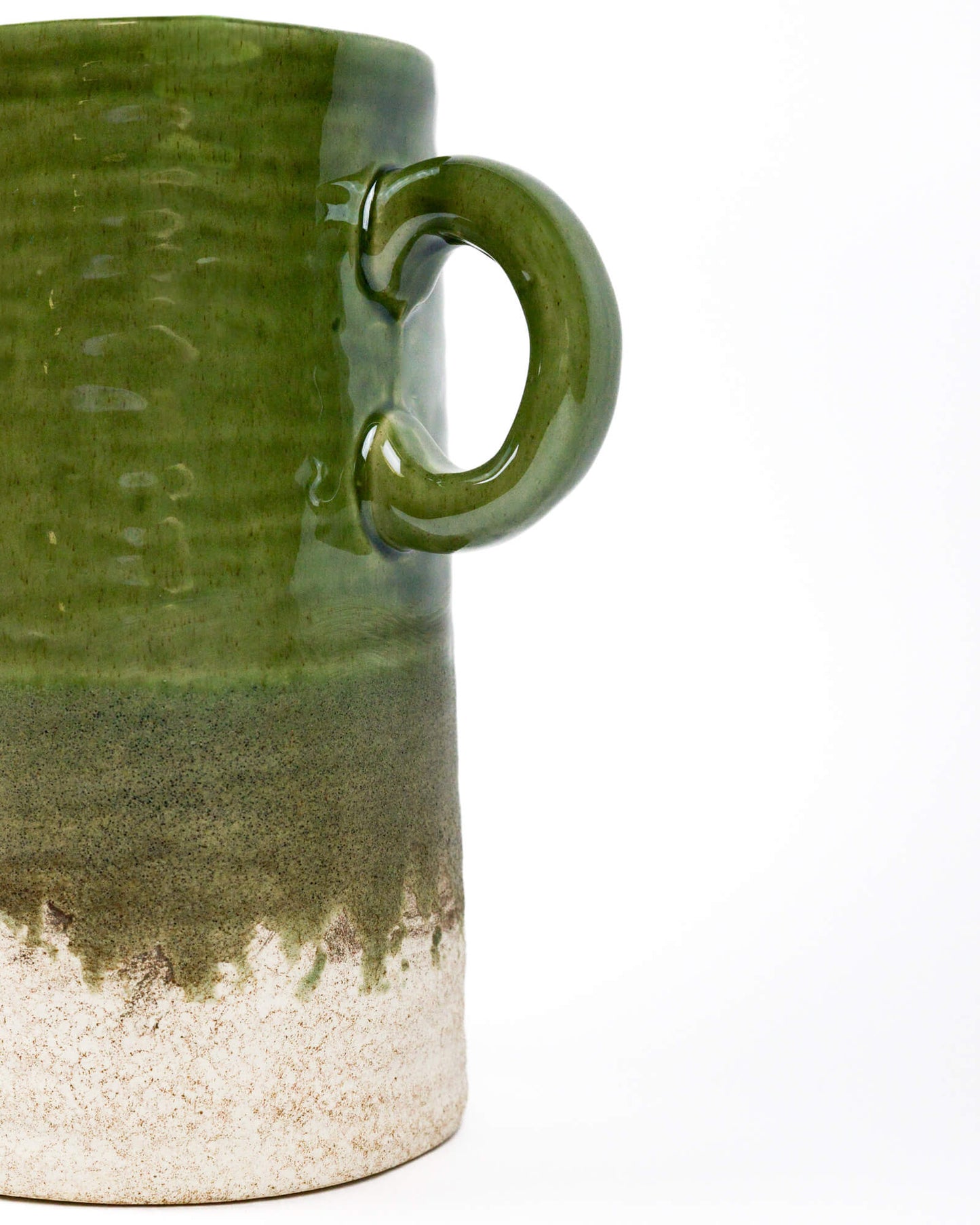 Olive reen ceramic jug with a textured glazed surface on a white background