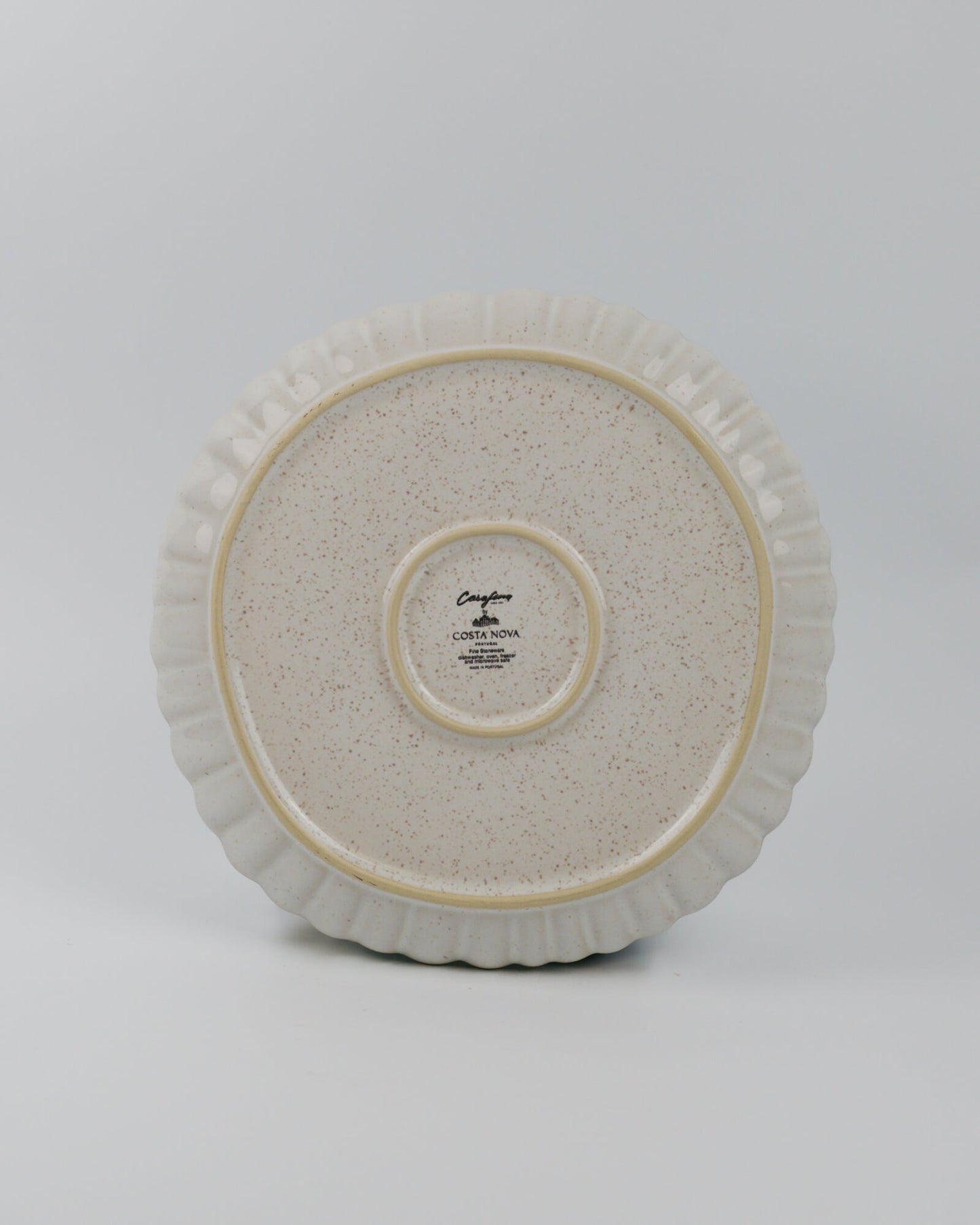 Round ceramic stonware dinner plate with textured surface on a white background