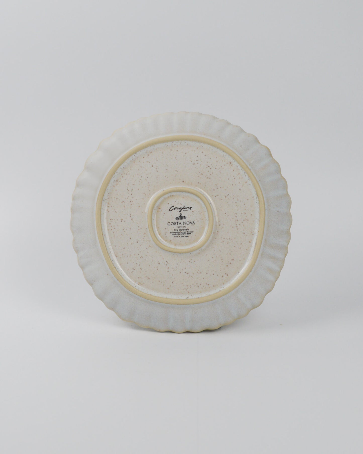 Round ceramic plate with textured surface on a white background