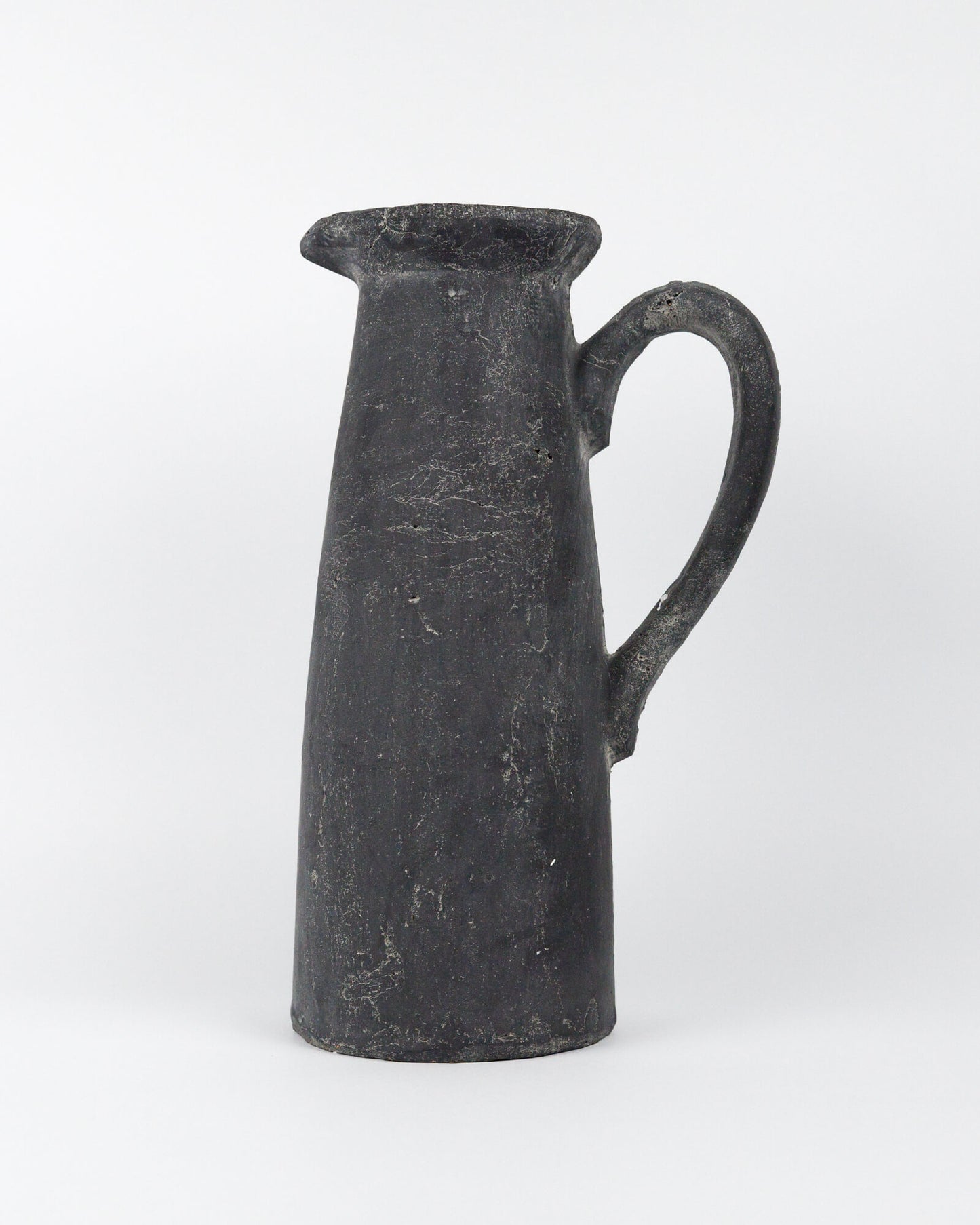 Dark grey ceramic pitcher on a white background