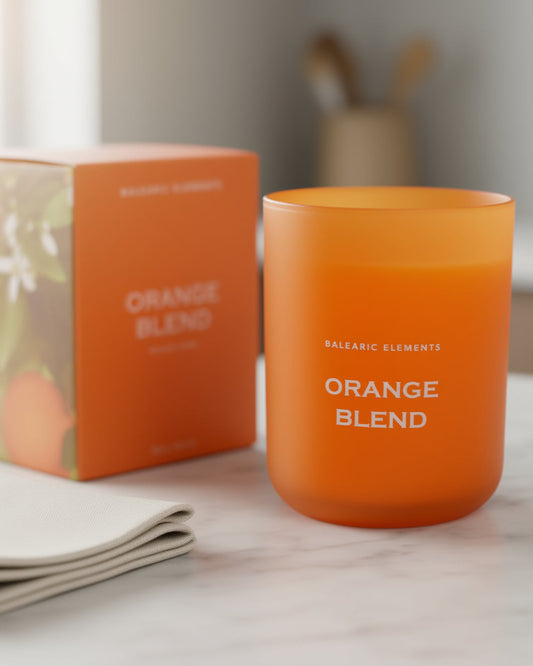 Orange scented candle labeled 'Orange Blend' next to its packaging on a light surface.
