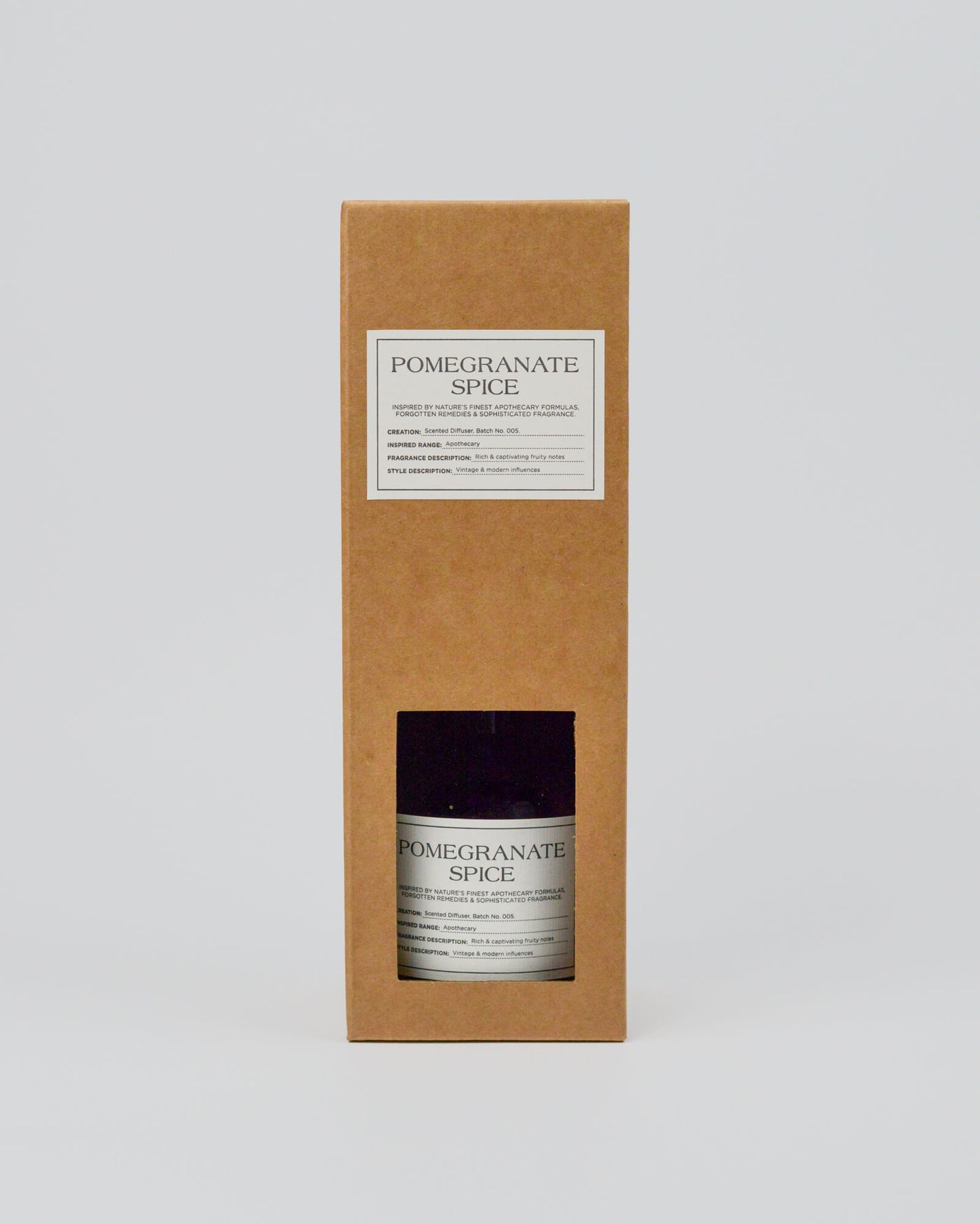 Bottle of 'Pomegranate Spice' in a cardboard box on a white background