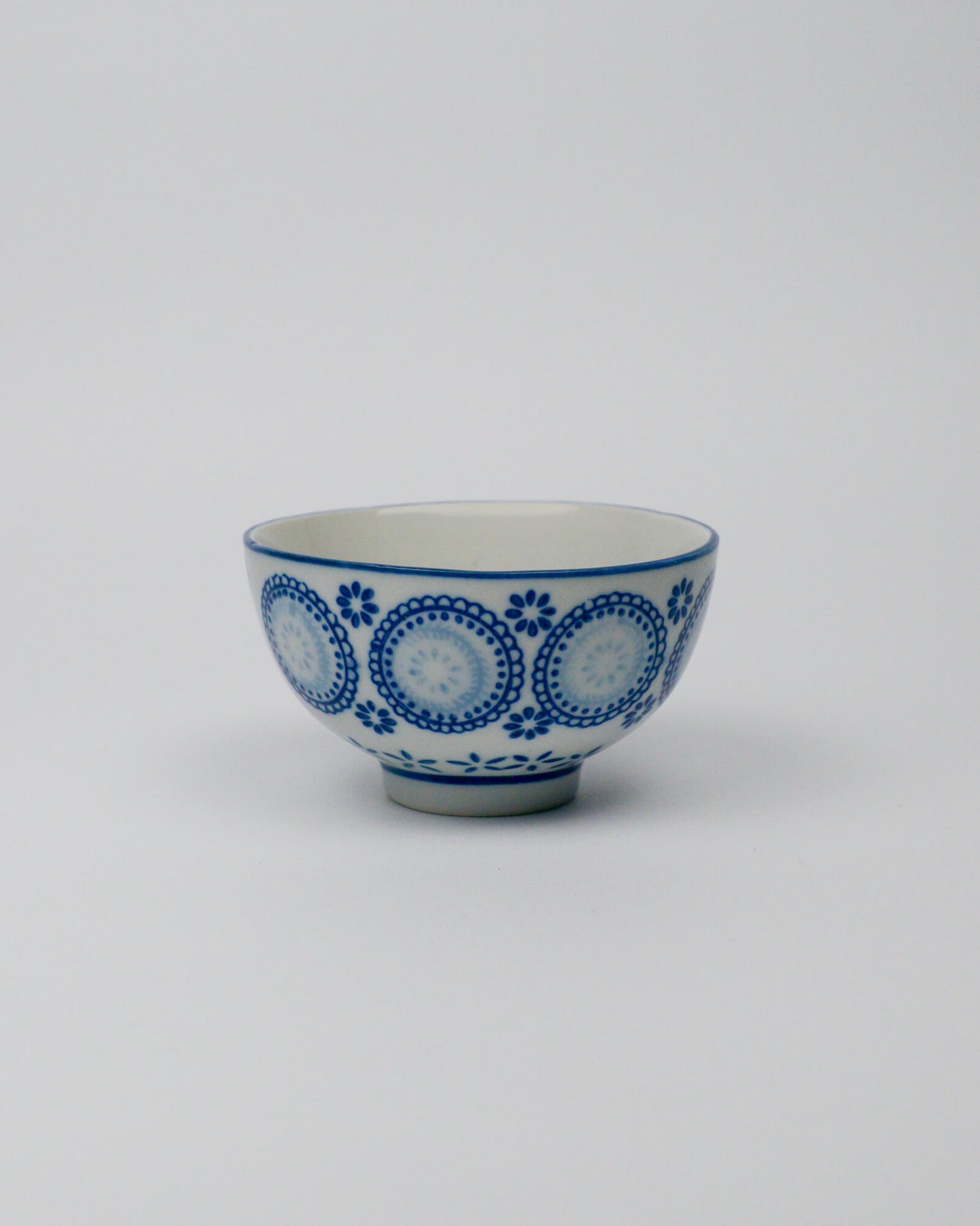 Ceramic bowl with blue circular patterns on a white background