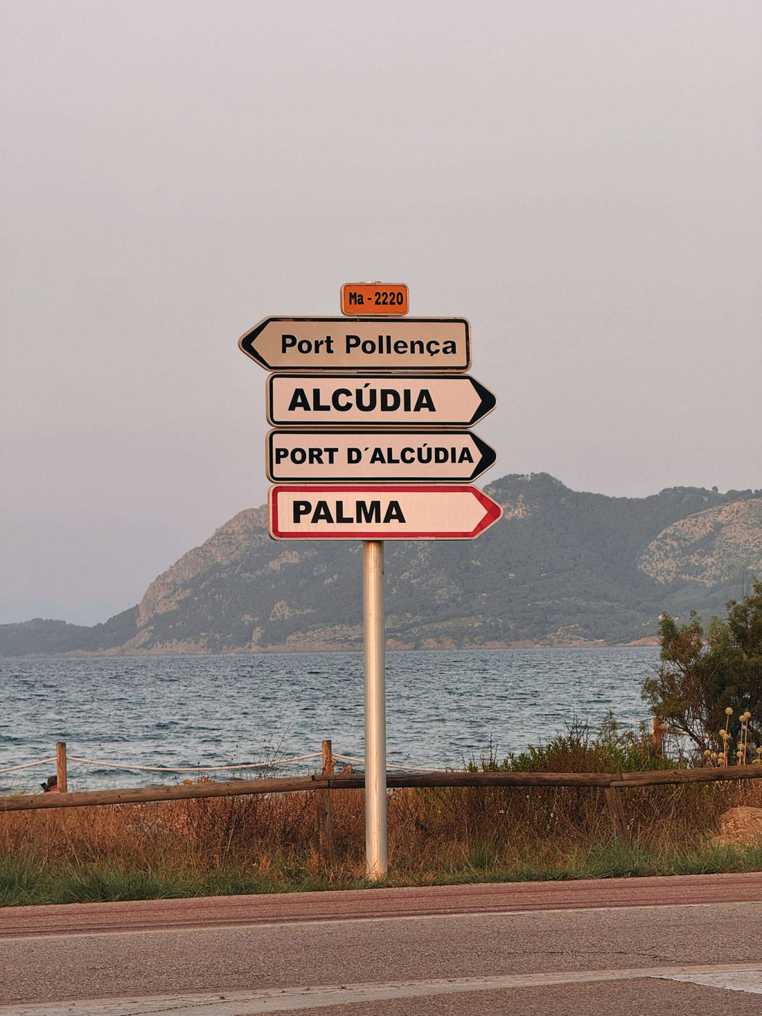 Picture of a street sign in Mallorca with the coastline in the background
