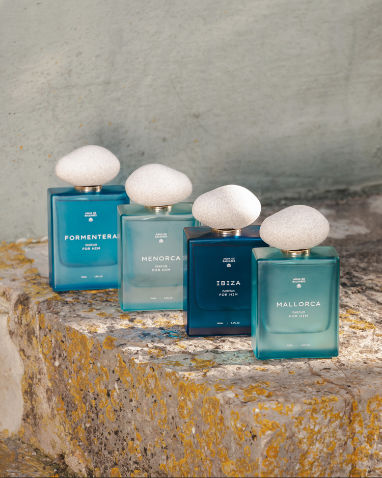 4 glass bottles of Islands Parfum by Agua de Bleares on a stone mediterranean wall