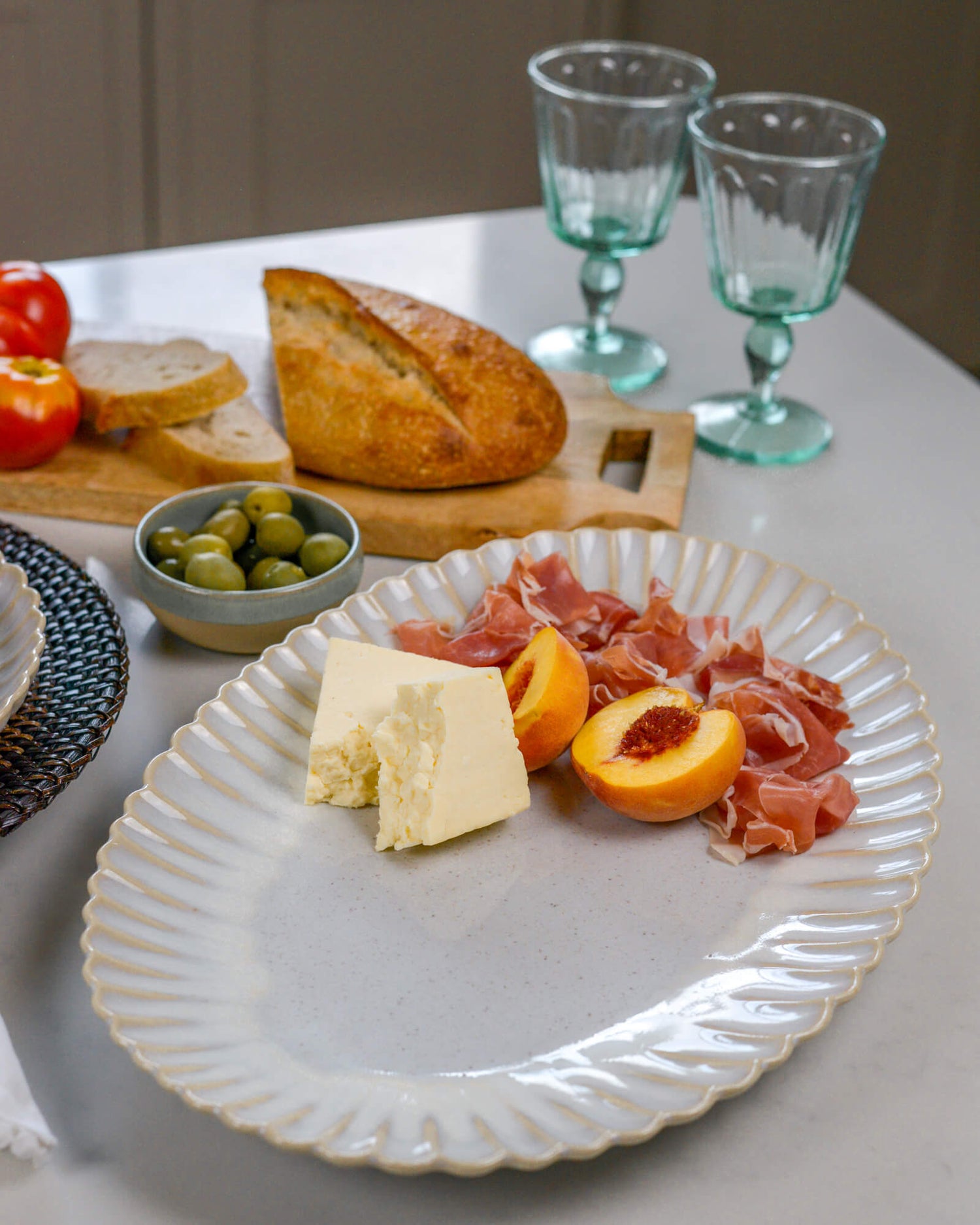 Beautiful scalloped edge serving platter with cheese and prosciutto