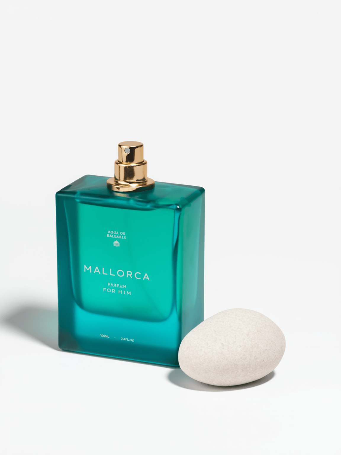 Mallorca Eau de Parfum for men in a translucent teal-green rectangular glass bottle with a gold spray cap, shown next to a smooth white stone on a white background.