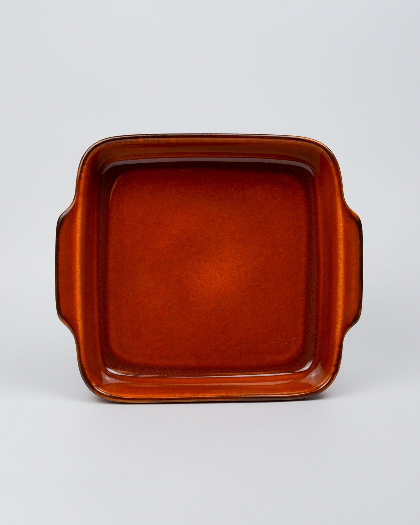 Burnt orange square stoneware ceramic baking dish on a white background