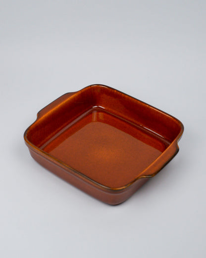 Burnt orange square ceramic baking dish on a white background