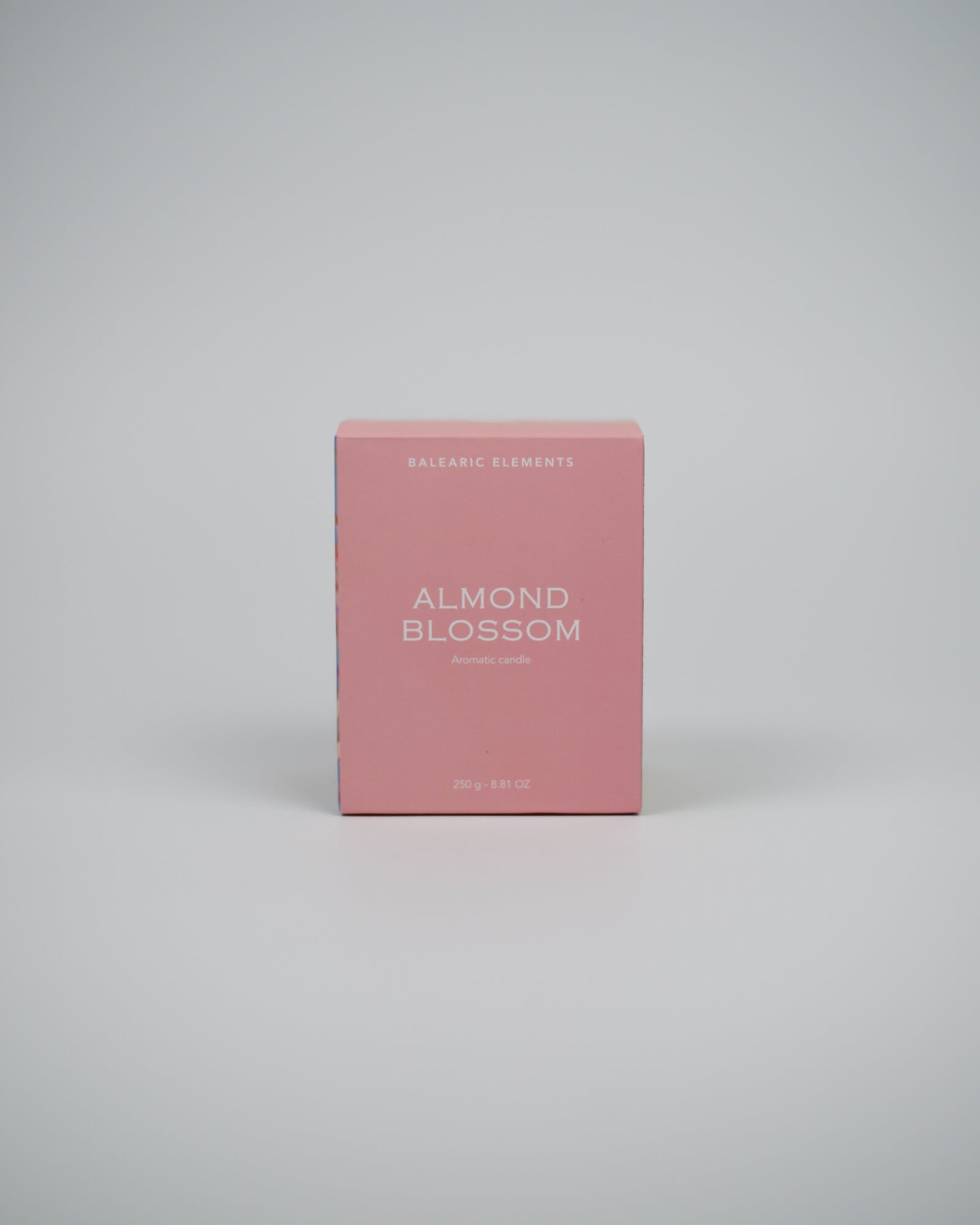 Pink candle box labeled 'Almond Blossom' on a white background