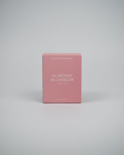 Pink candle box labeled 'Almond Blossom' on a white background