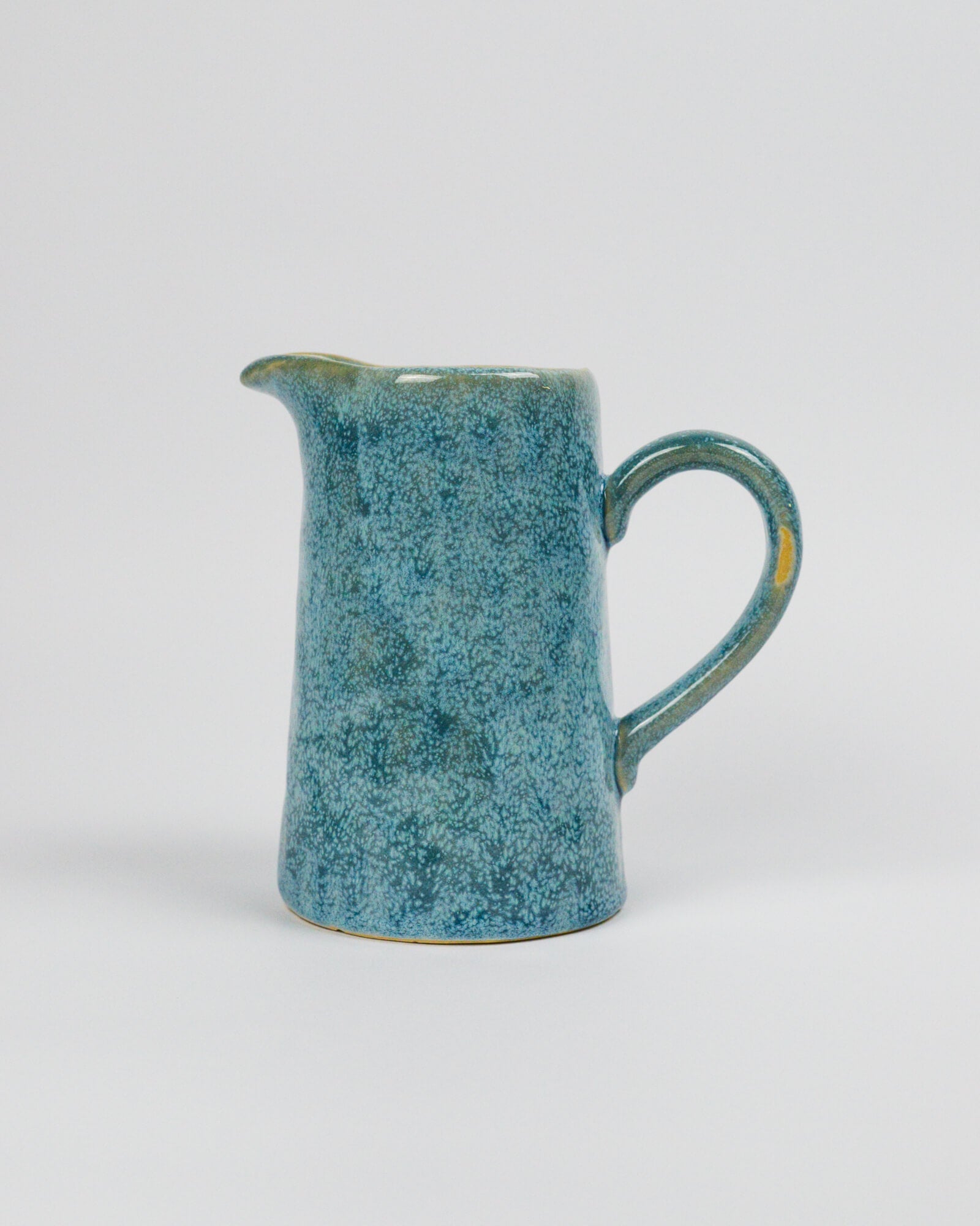 Blue ceramic pitcher on a white background