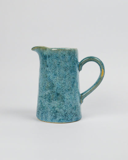 Blue ceramic pitcher on a white background