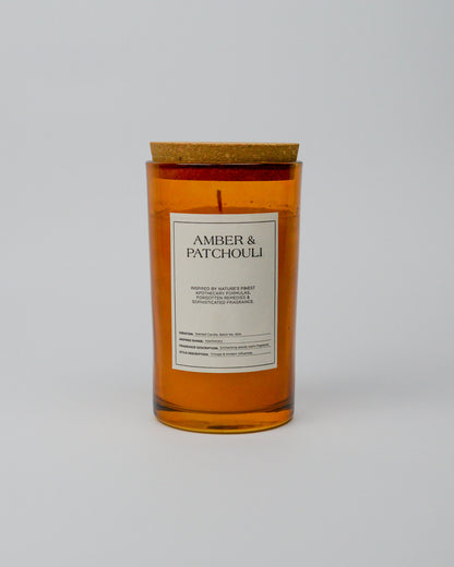 Candle with 'Amber & Patchouli' label on a white background