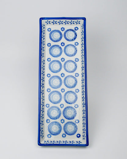 Rectangular ceramic tray with blue circular patterns on a white background