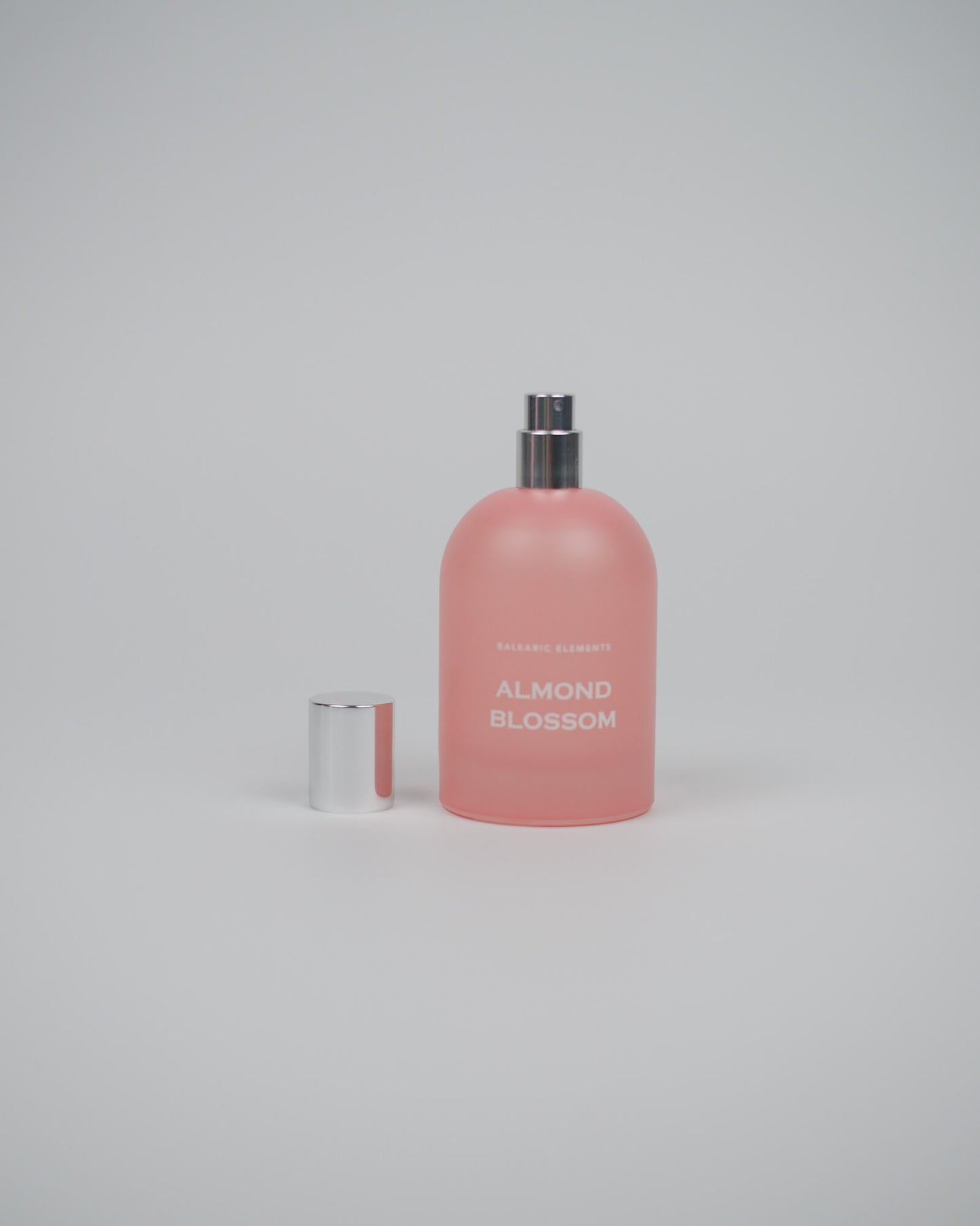 Pink eau de toilette bottle labeled 'Almond Blossom' on a white background