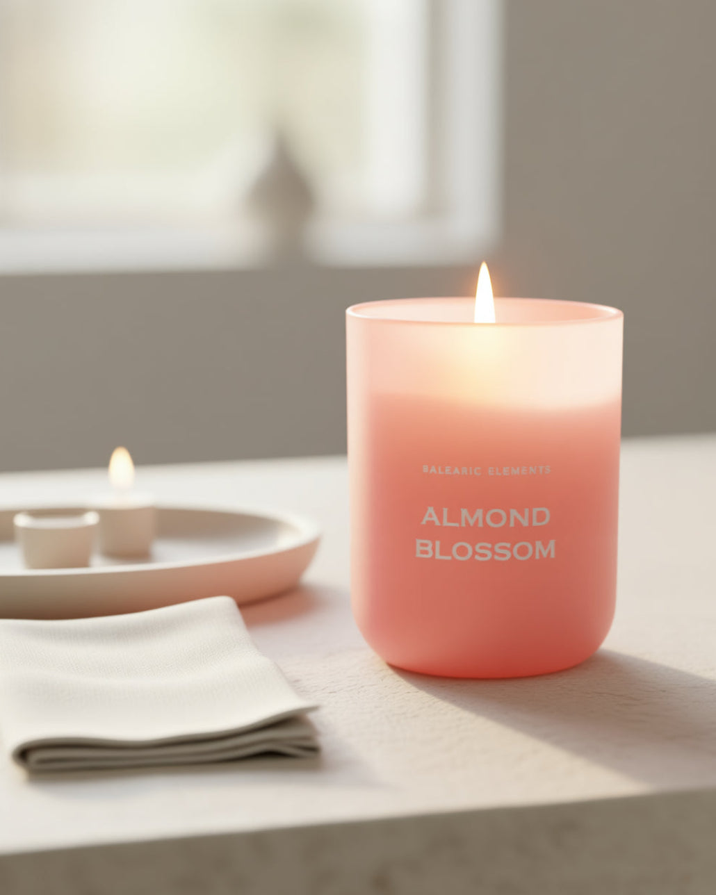 Pink 'Almond Blossom' scented candle on a table with a blurred background