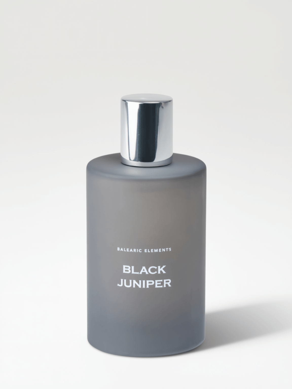 A frosted gray bottle of Balearic Elements Black Juniper with a reflective silver cap, set against a clean light gray background.