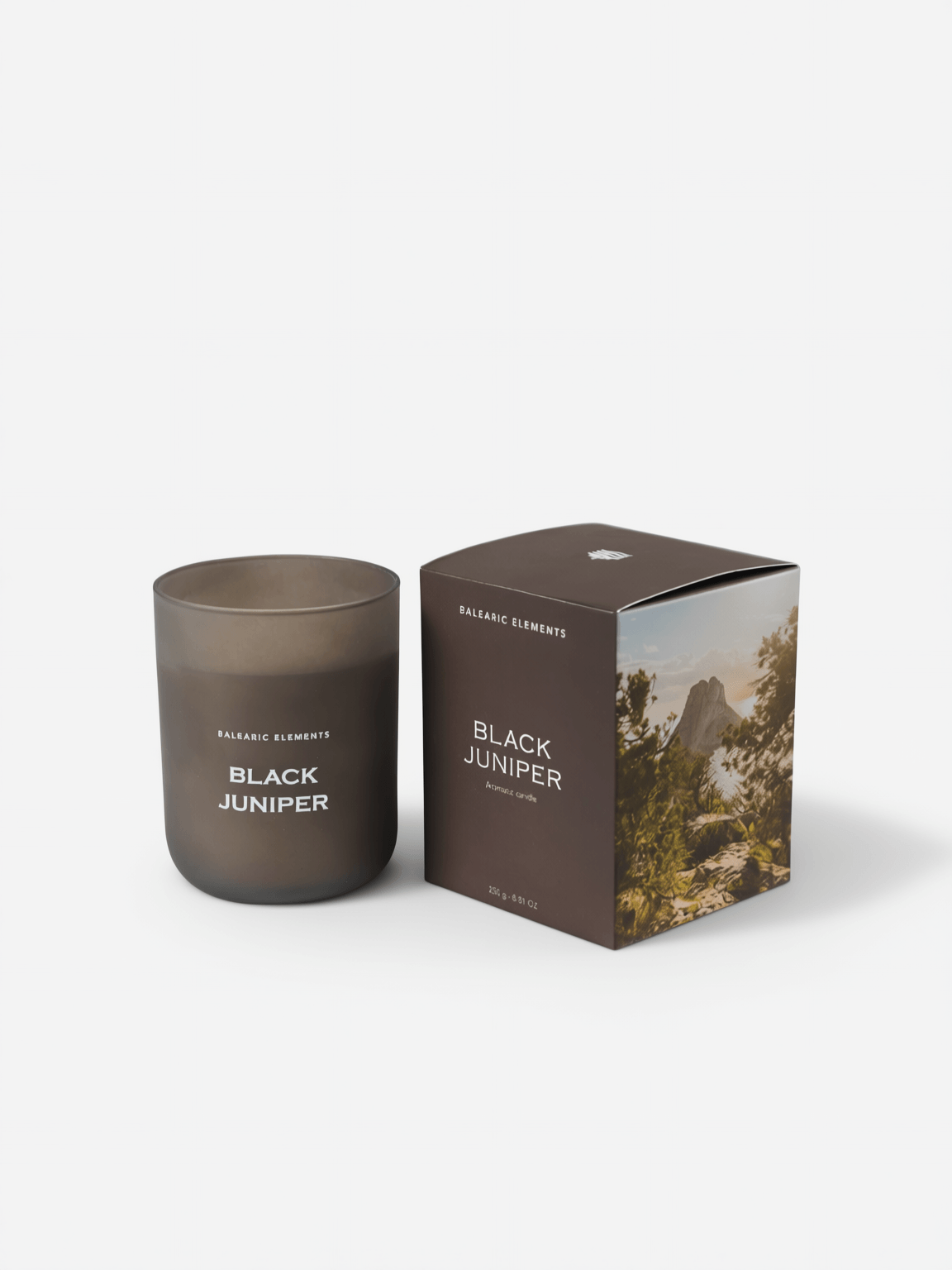 A matte dark grey glass jar candle next to its matching brown packaging box, both labeled 'BALEARIC ELEMENTS BLACK JUNIPER' on a clean white background.