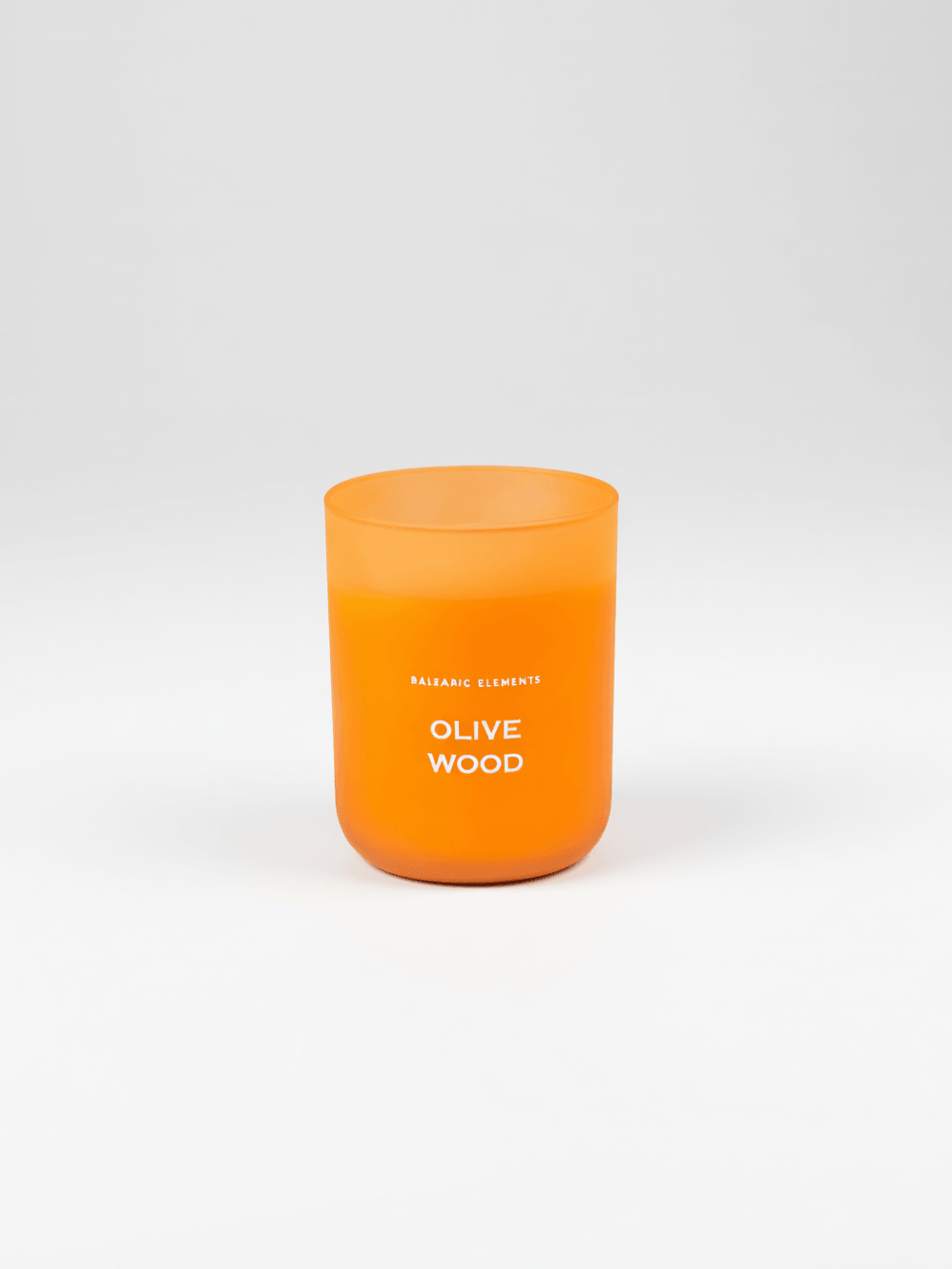 An orange frosted glass candle jar with white text reading 'OLIVE WOOD' on a clean white background.