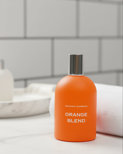 Orange perfume bottle labeled 'Orange Blend' on a bathroom counter with a tiled wall background
