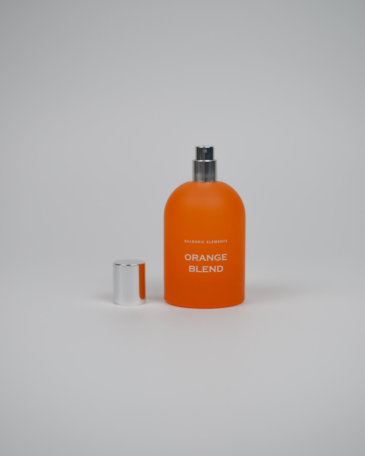 Orange perfume bottle labeled 'Orange Blend' on a white background