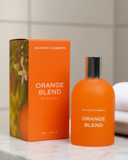 Orange Blend perfume bottle and packaging on a marble surface with a towel in the background