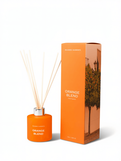 Orange reed diffuser bottle with natural reeds and a silver cap, shown next to its orange packaging box featuring an orange tree illustration. The text reads 'ORANGE BLEND' and 'BALEARIC ELEMENTS'.