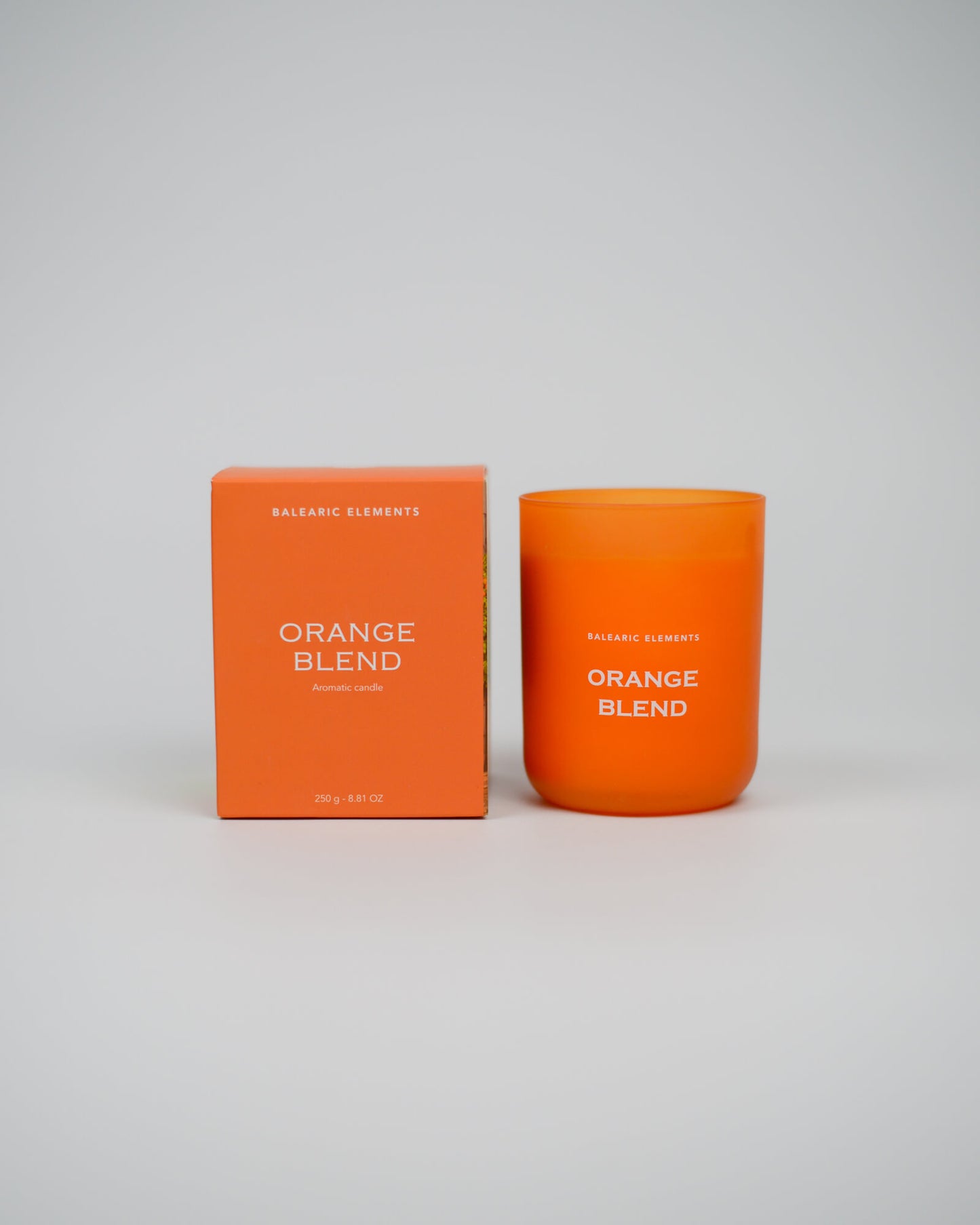 Orange scented candle and packaging with 'Orange Blend' text on a white background