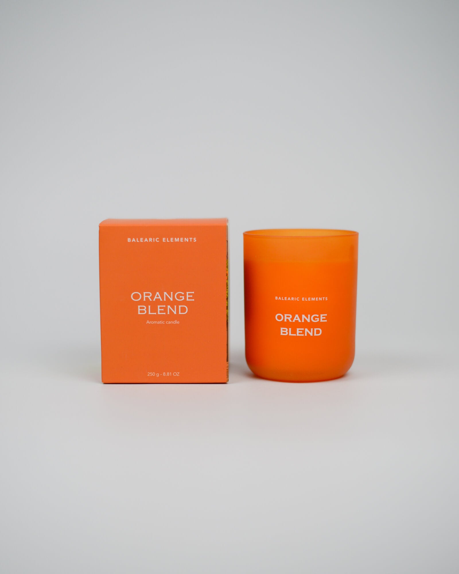 Orange scented candle and packaging with 'Orange Blend' text on a white background