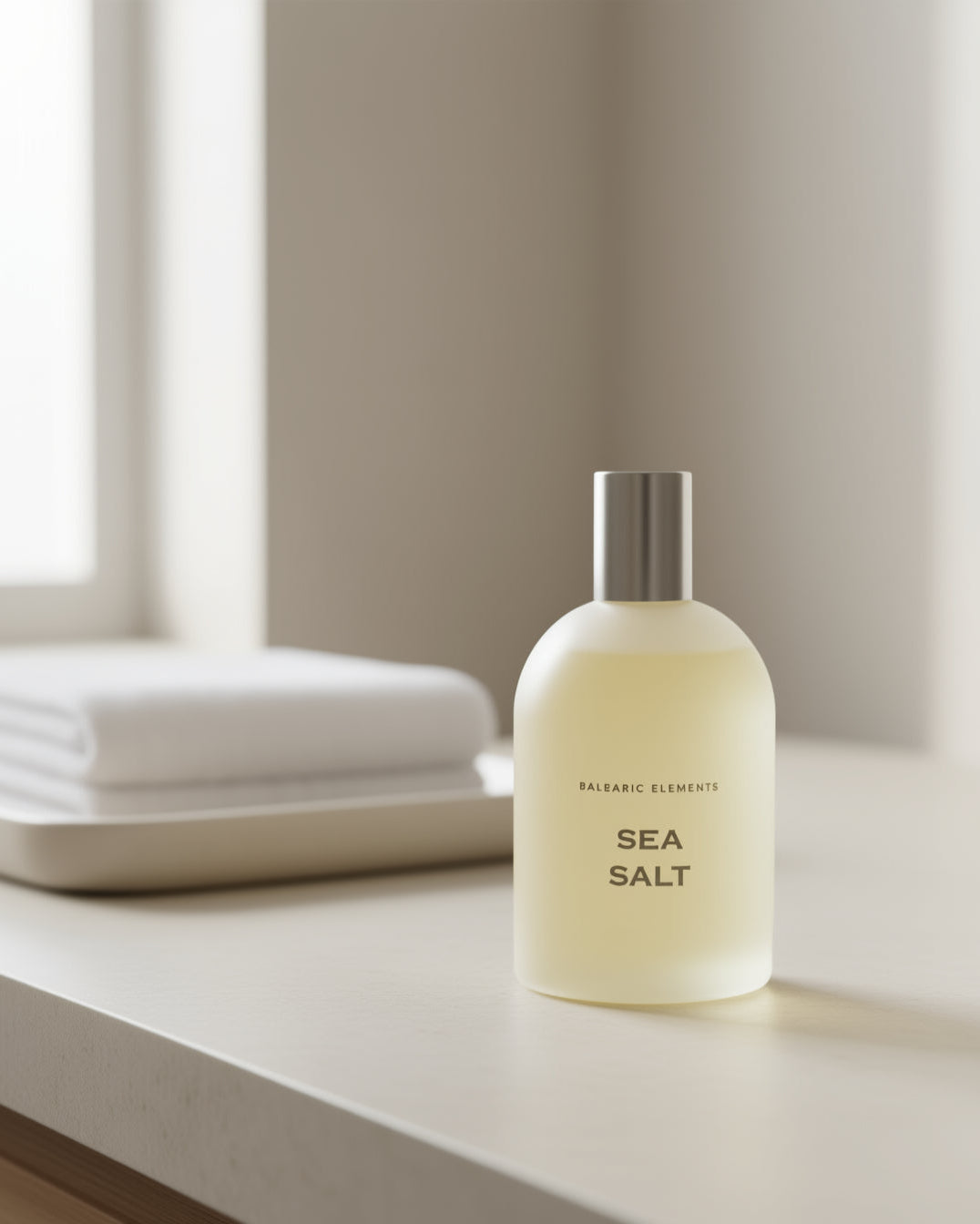 Sea Salt Unisex Eau de Toilette on a neutral marble surface with a washcloth in the background 