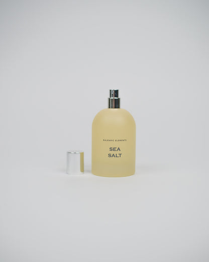 Glass perfume bottle labeled 'Sea Salt' on a white background