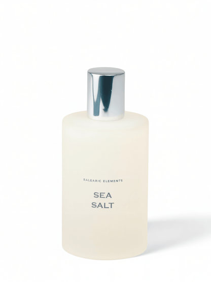 A frosted glass bottle of Balearic Elements Sea Salt bath product with a reflective silver cap, set against a clean white background.