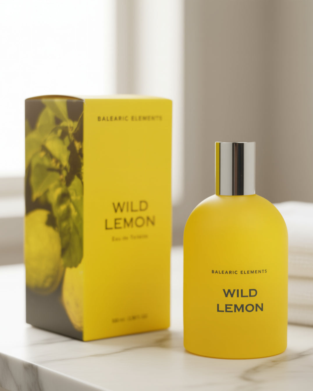 Yellow 'Wild Lemon' perfume bottle and packaging on a marble surface with a blurred background