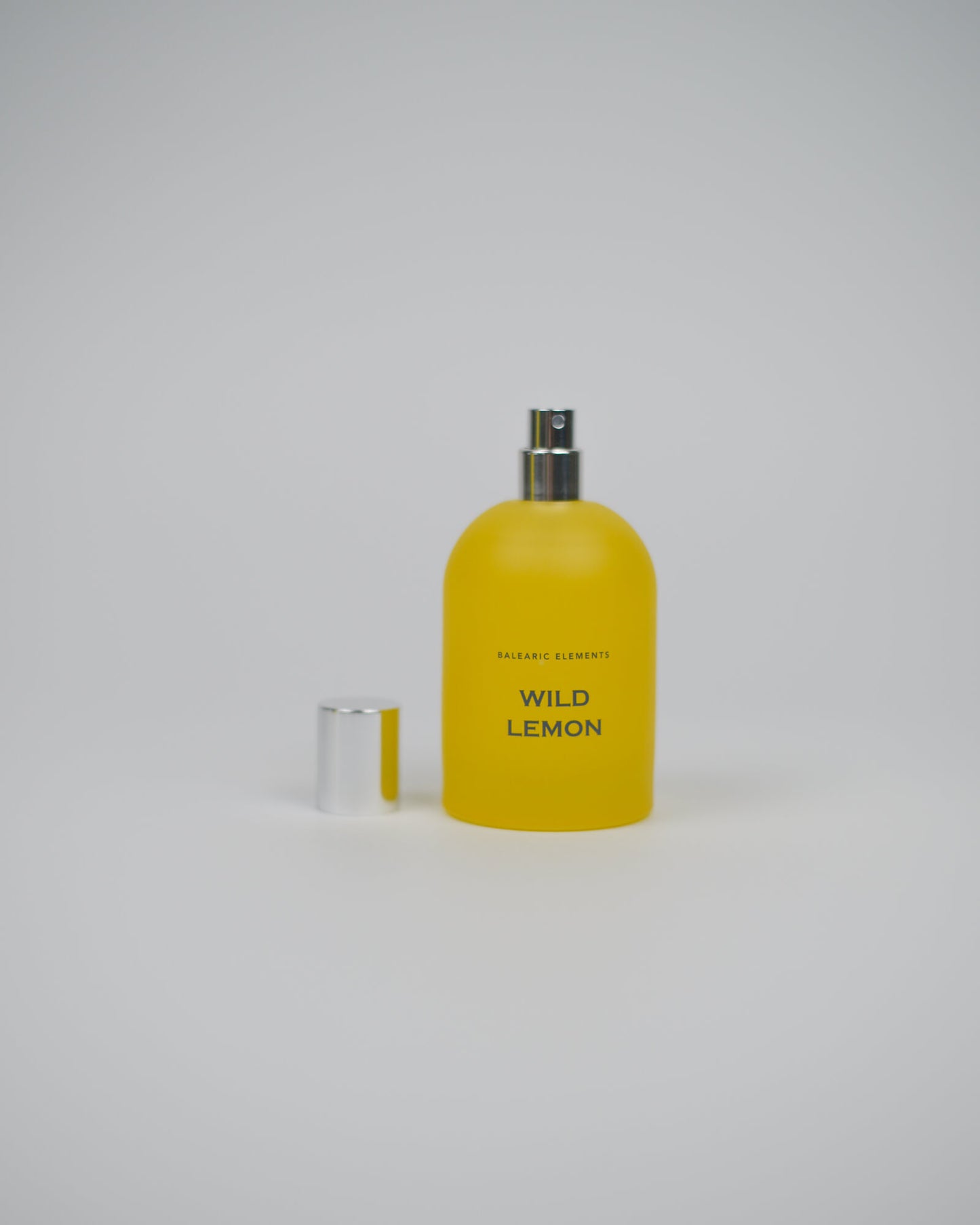 Yellow perfume spray bottle labeled 'Wild Lemon' on a white background