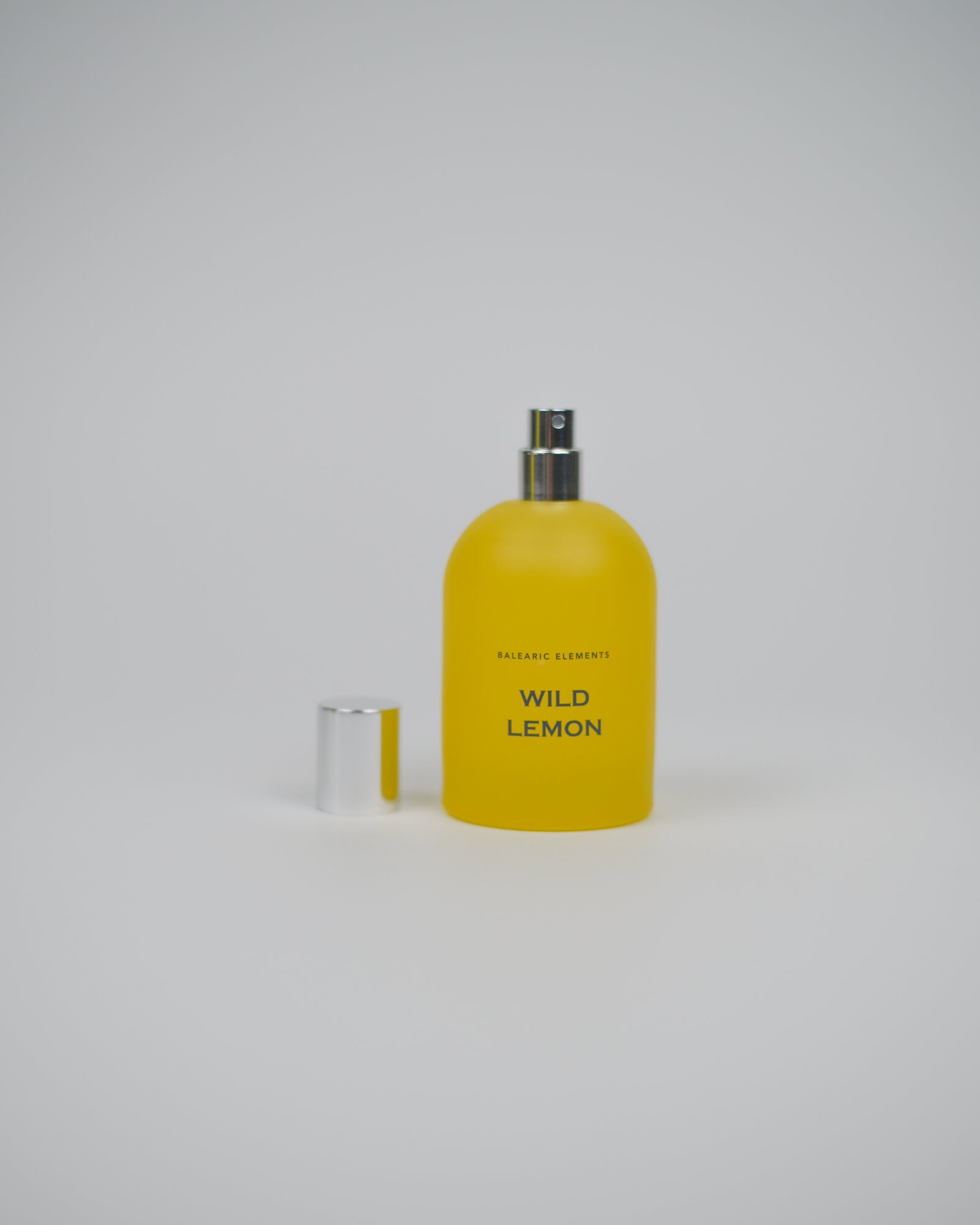 Yellow perfume spray bottle labeled 'Wild Lemon' on a white background