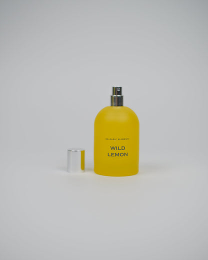 Yellow perfume spray bottle labeled 'Wild Lemon' on a white background