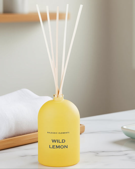 Yellow diffuser bottle labeled 'Wild Lemon' on a marble surface with a neutral background