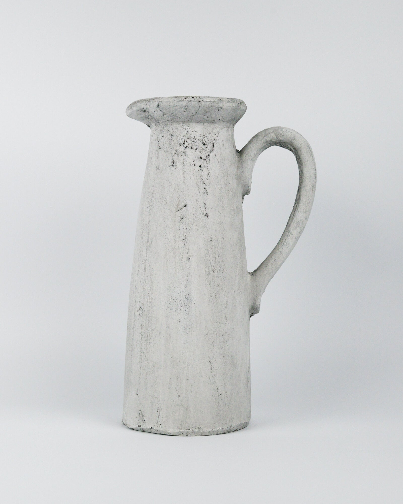 Grey ceramic pitcher on a white background