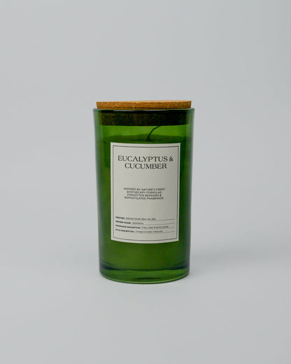 Green eucalyptus and cucumber candle with a cork lid on a white background