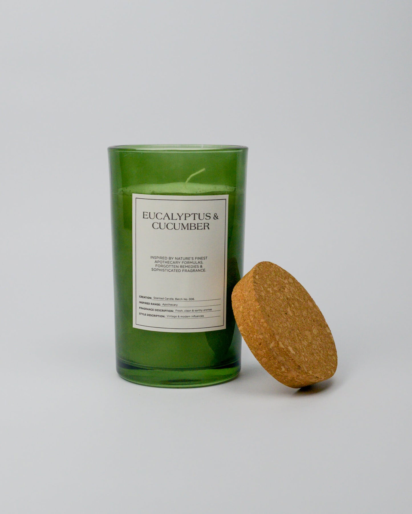 Green eucalyptus and cucumber candle with a cork lid on a white background