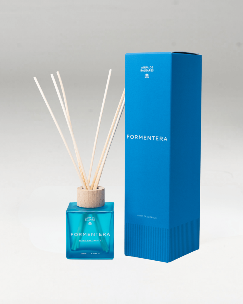 A Formentera reed diffuser with a bright blue glass bottle, natural wood reeds, and a tall matching blue box on a white background.