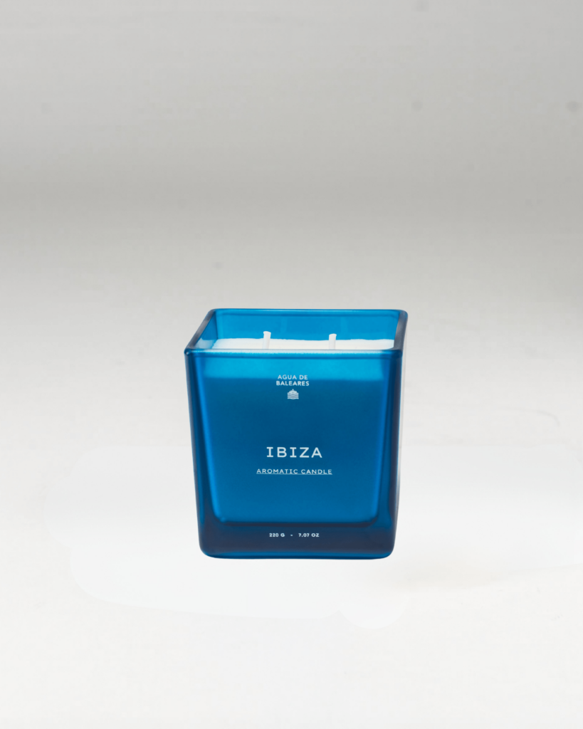 A blue glass jar candle featuring the scent name 'IBIZA' on a clean white background.