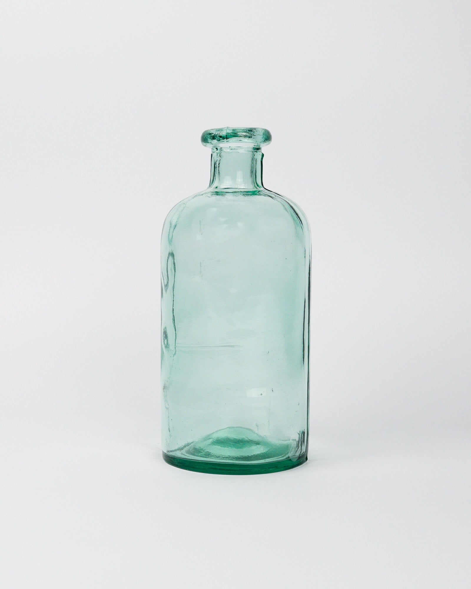 Small green decorative glass bottle on a white background
