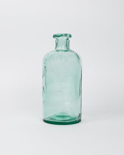 Small green decorative glass bottle on a white background