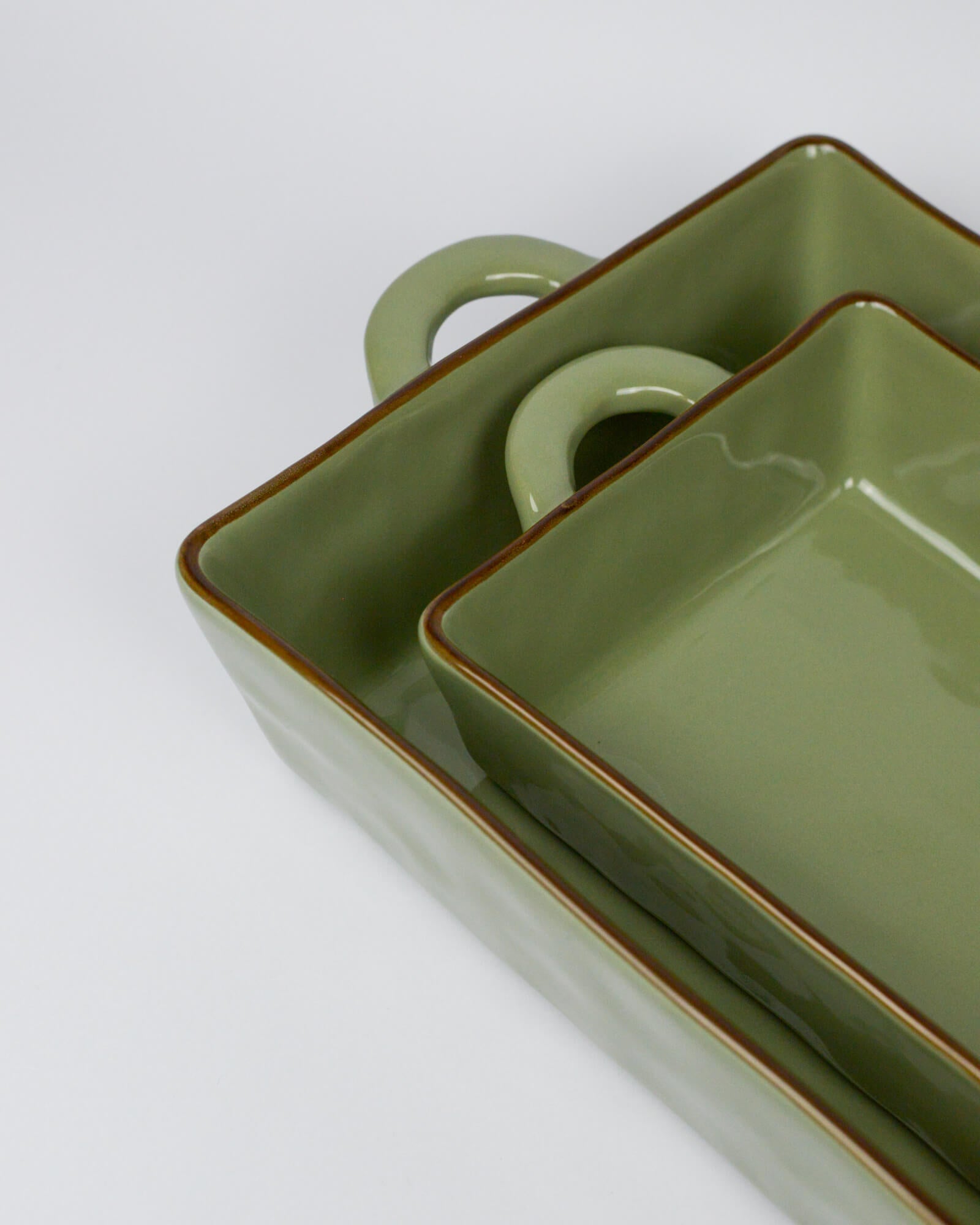 Green ceramic dish with handle on a white background