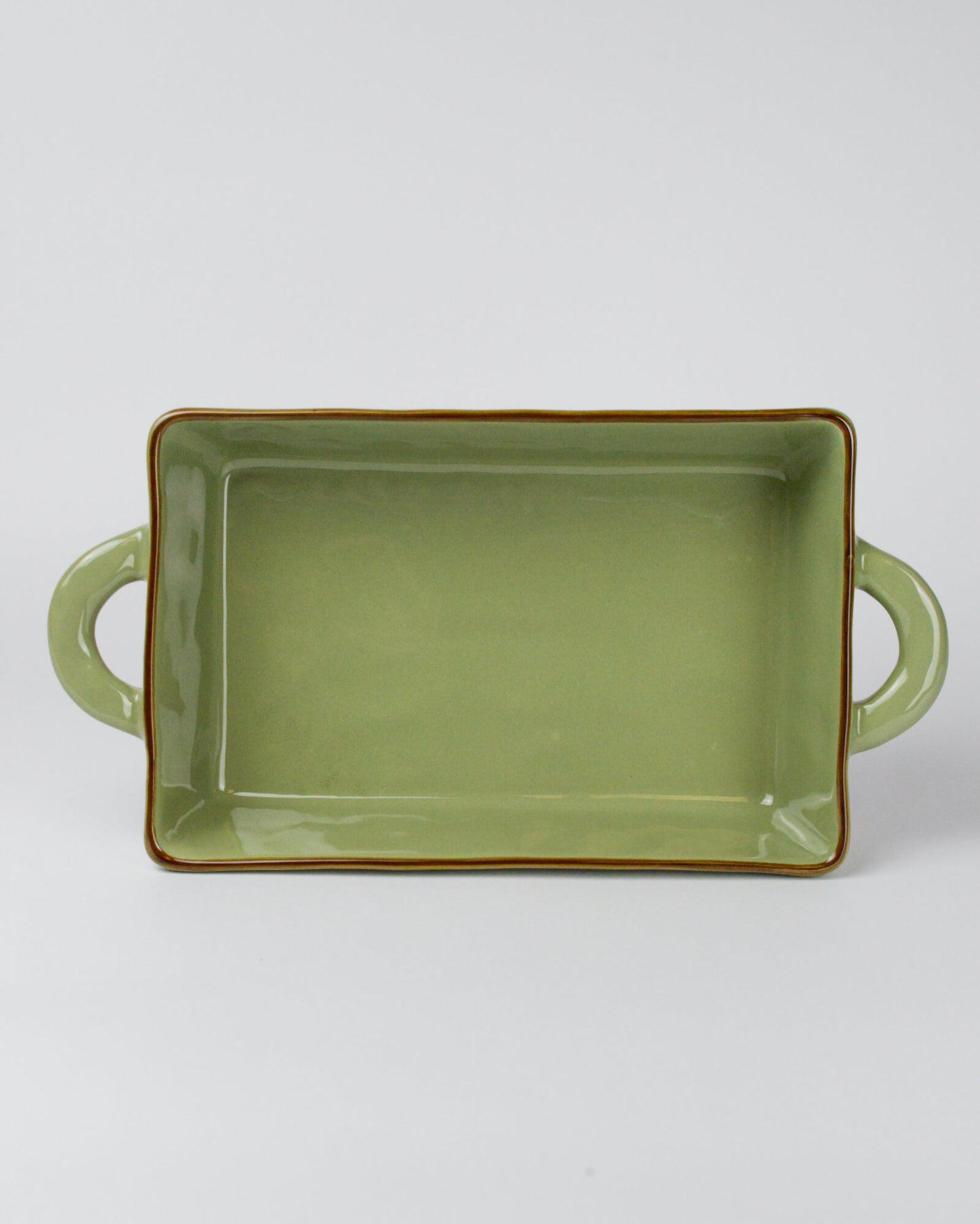 Green rectangular ceramic dish with handles on a white background