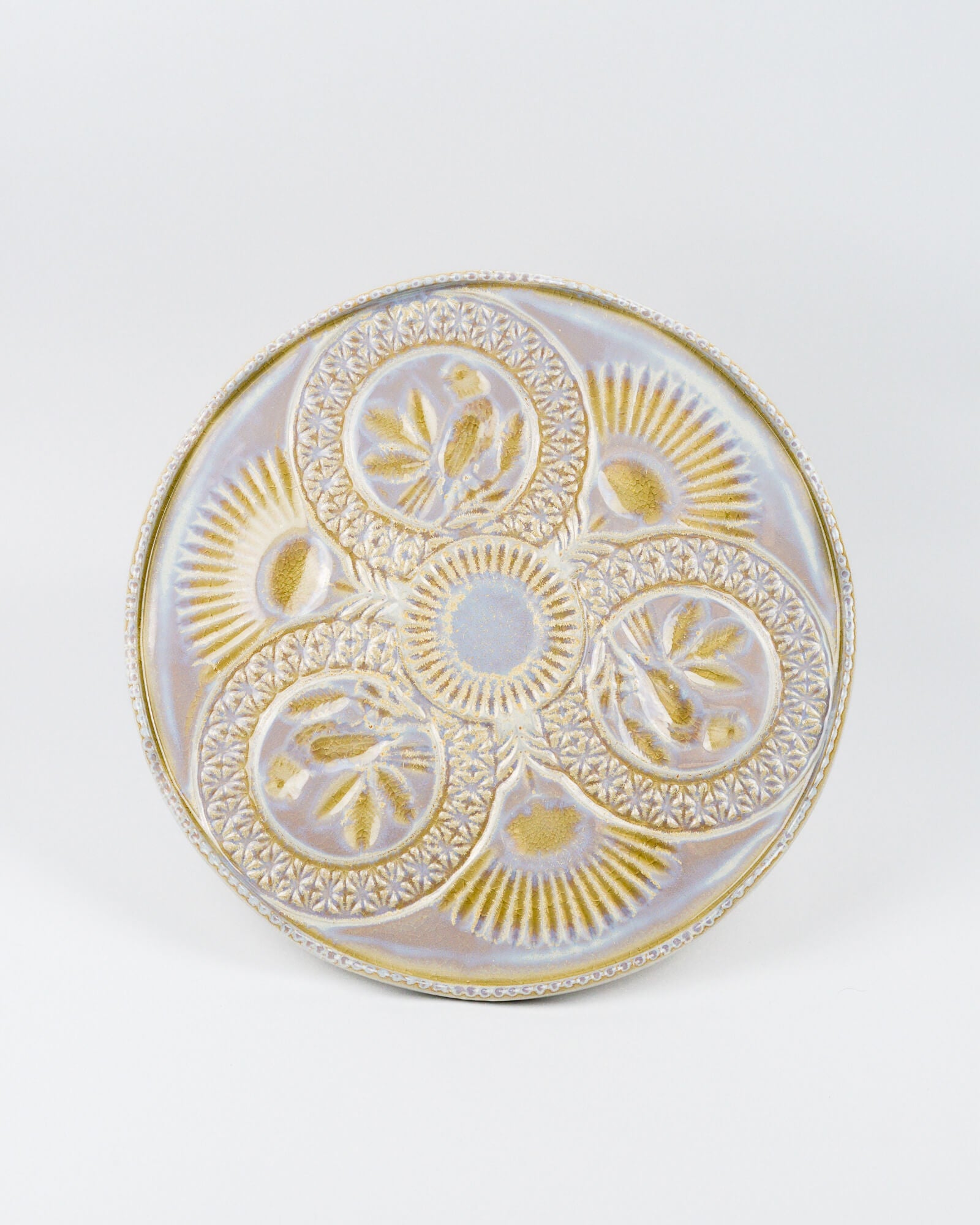 Top view of a decorative cake stand with gold and white patterns on a white background